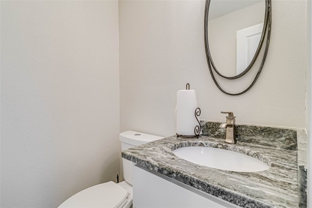 bathroom featuring toilet and vanity