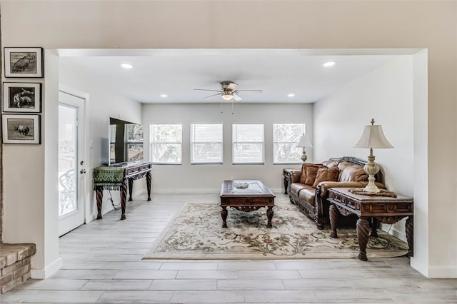 living room with light wood-style floors, ceiling fan, baseboards, and recessed lighting