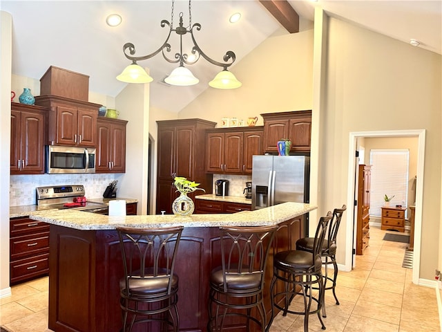 kitchen with decorative backsplash, stainless steel appliances, a breakfast bar, and an island with sink