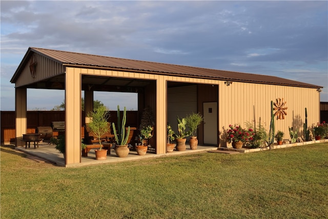 rear view of property featuring a lawn and a patio area