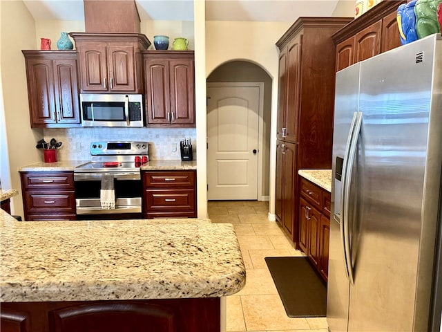 kitchen with backsplash, light tile patterned floors, and appliances with stainless steel finishes