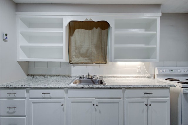 kitchen with light stone counters, decorative backsplash, sink, white cabinetry, and white range with electric stovetop