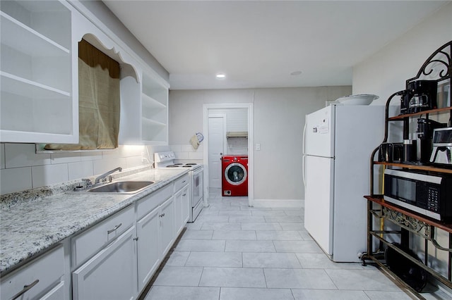 kitchen with sink, light tile patterned floors, white cabinetry, washer / clothes dryer, and white appliances