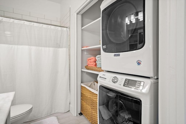 clothes washing area with stacked washer / drying machine and laundry area