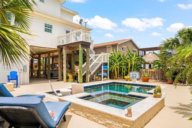 view of pool featuring a patio area, fence, stairway, and an in ground hot tub