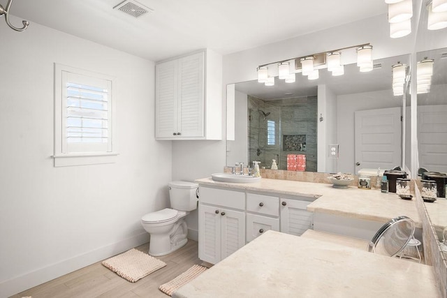 full bath featuring baseboards, visible vents, wood finished floors, vanity, and a shower stall