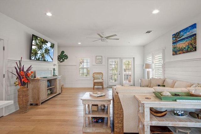 living area featuring light wood finished floors, recessed lighting, visible vents, and wainscoting