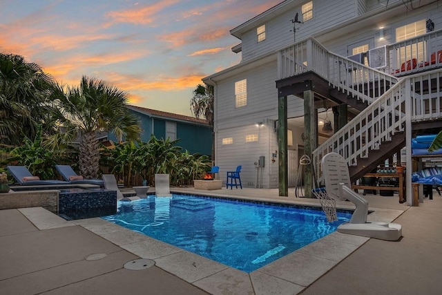 outdoor pool featuring stairway, a patio area, and a hot tub