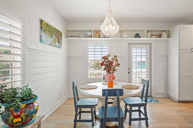 dining room with light wood finished floors and an inviting chandelier