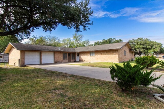 1414 Mockingbird Ln, Beeville, TX 78102 - ranch-style home featuring an attached garage, brick siding, and concrete driveway