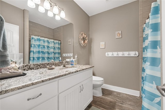 413 6th St, Port Aransas, TX 78373 - bathroom featuring vanity, baseboards, curtained shower, toilet, and wood finished floors