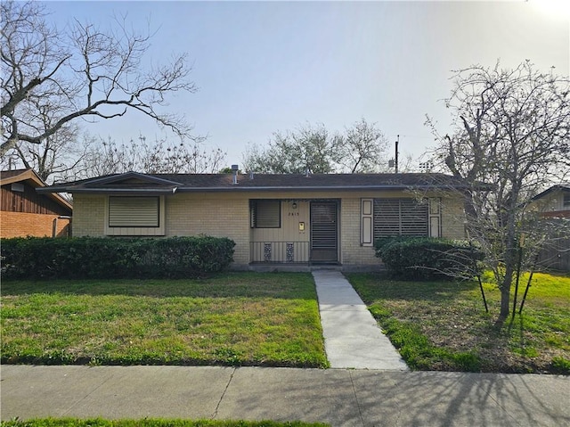 view of front of home featuring brick siding and a front lawn