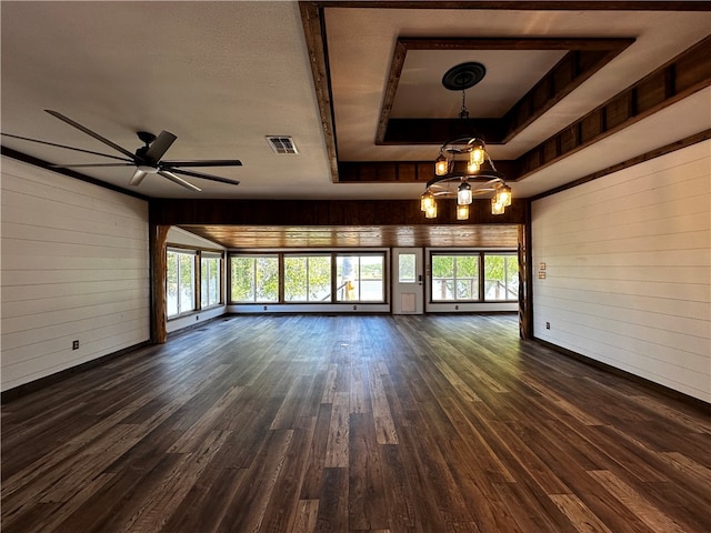 unfurnished living room featuring wood walls, dark hardwood / wood-style floors, and plenty of natural light