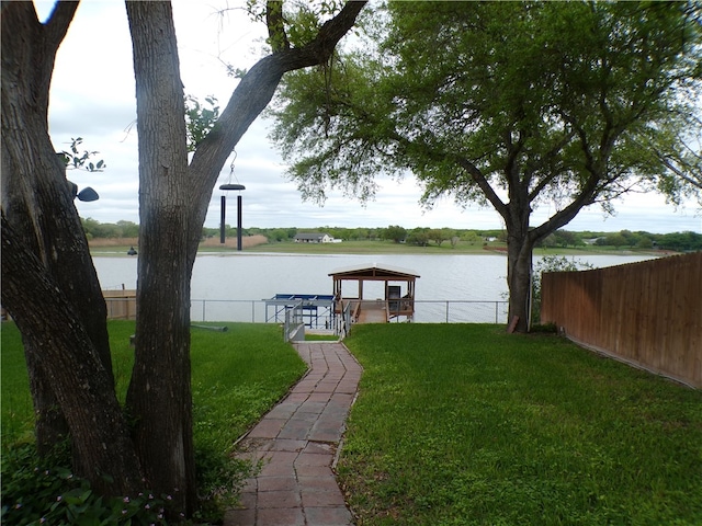 dock area featuring a water view and a lawn