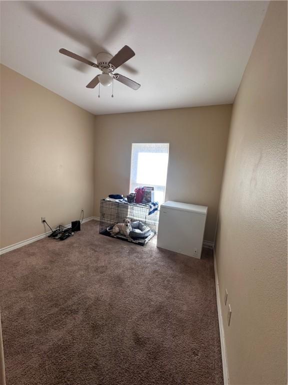 misc room featuring baseboards, carpet, and a ceiling fan