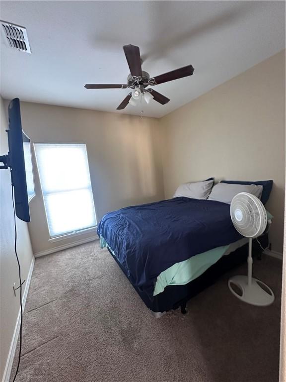 bedroom featuring visible vents, baseboards, carpet, and ceiling fan