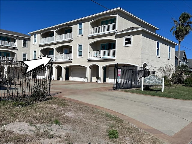 view of property with an attached garage, fence, and driveway