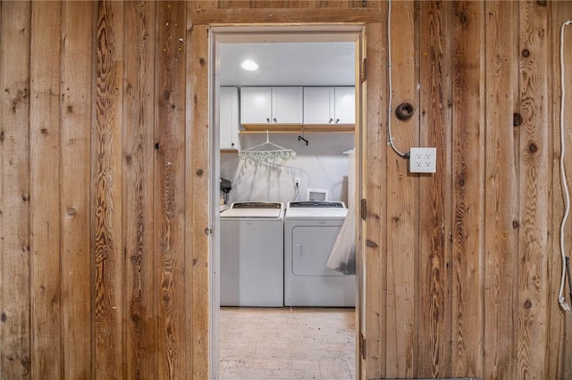 110 Wildwood, Rockport, TX 78382 - washroom featuring washer and dryer, wood walls, and cabinet space