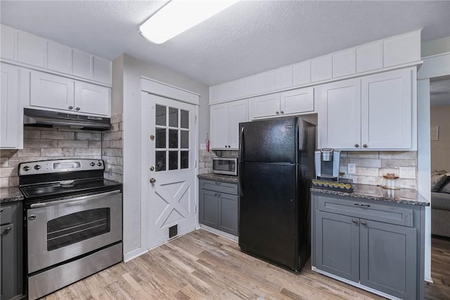 110 Wildwood, Rockport, TX 78382 - kitchen with stainless steel appliances, under cabinet range hood, backsplash, dark stone countertops, and a textured ceiling