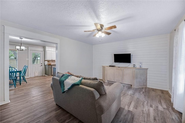 110 Wildwood, Rockport, TX 78382 - living room featuring wood finished floors, ceiling fan, a textured ceiling, and a chandelier
