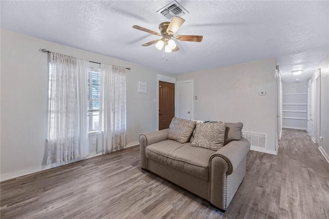 110 Wildwood, Rockport, TX 78382 - living area featuring wood finished floors, a textured ceiling, and ceiling fan