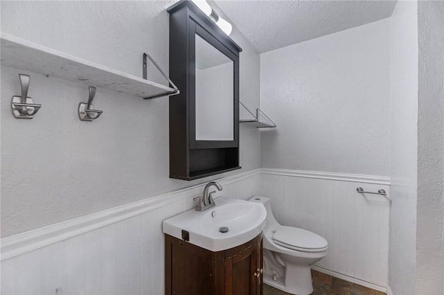110 Wildwood, Rockport, TX 78382 - half bath with a wainscoted wall, vanity, and a textured ceiling