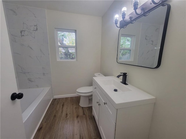 full bathroom with hardwood / wood-style floors, vanity, shower / bath combination, and toilet