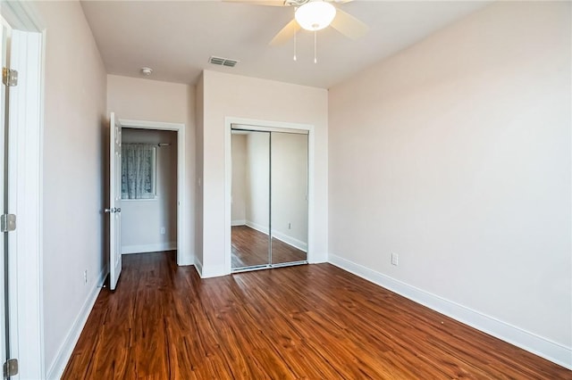 unfurnished bedroom featuring ceiling fan, dark hardwood / wood-style flooring, and a closet