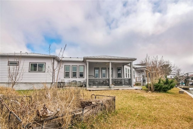 back of property featuring a yard and covered porch