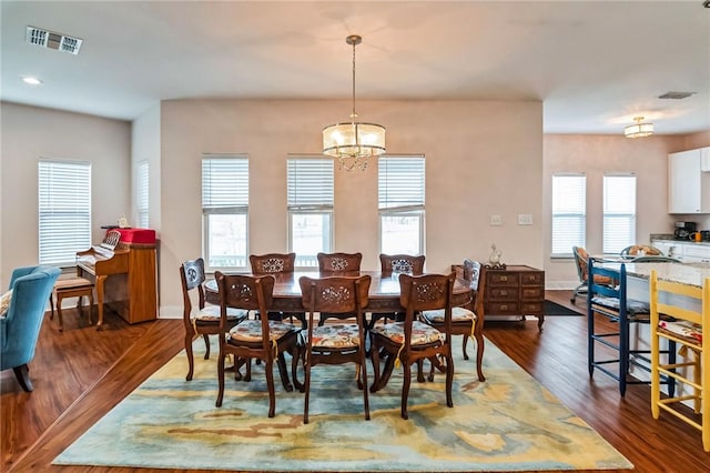 dining room featuring dark wood-type flooring and a chandelier