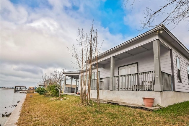 view of property exterior featuring a water view, a yard, and covered porch