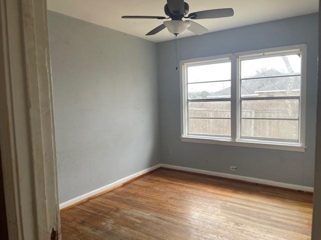 empty room featuring ceiling fan, a wealth of natural light, and light wood-type flooring