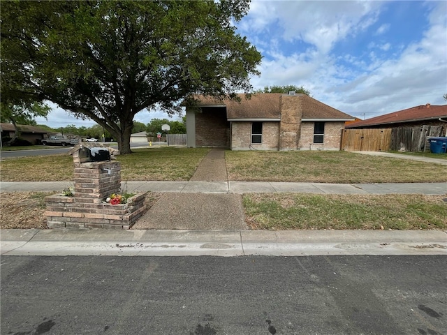 view of front facade featuring a front lawn and fence
