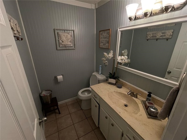 bathroom with tile patterned flooring, baseboards, toilet, and vanity