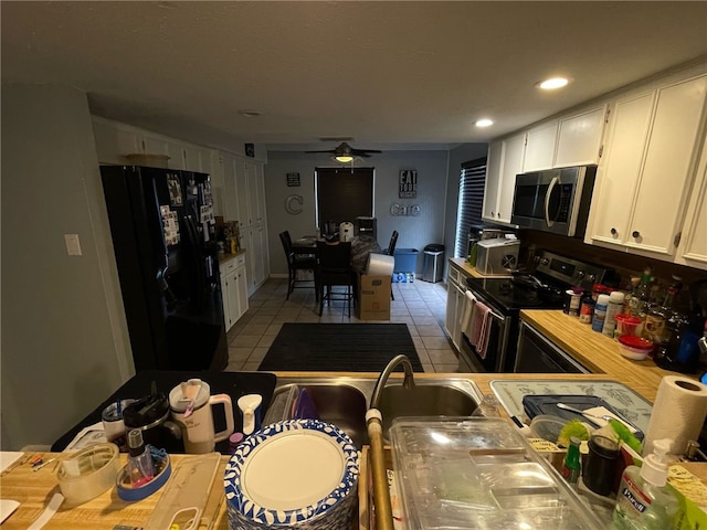 kitchen with a ceiling fan, light tile patterned floors, white cabinetry, light countertops, and appliances with stainless steel finishes