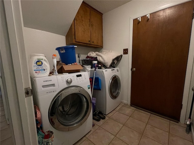 washroom with separate washer and dryer, a textured ceiling, light tile patterned floors, and cabinet space