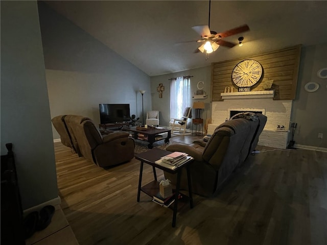 living room with a ceiling fan, a fireplace, baseboards, lofted ceiling, and dark wood-style floors