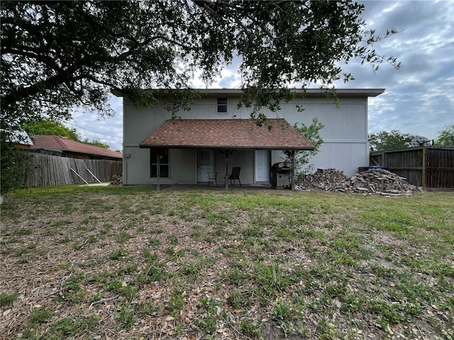 back of house with a lawn and a fenced backyard