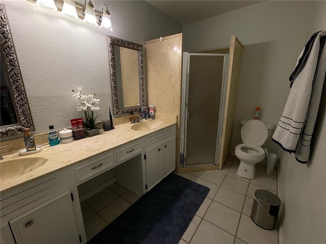 bathroom with a shower stall, tile patterned floors, and a sink