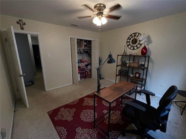 office space with baseboards, a ceiling fan, visible vents, and carpet