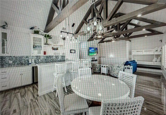 dining area featuring beamed ceiling, high vaulted ceiling, and hardwood / wood-style floors