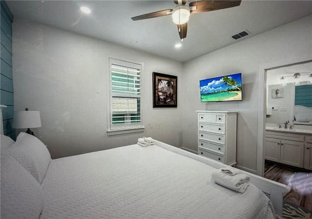 bedroom featuring hardwood / wood-style flooring, ceiling fan, and ensuite bath