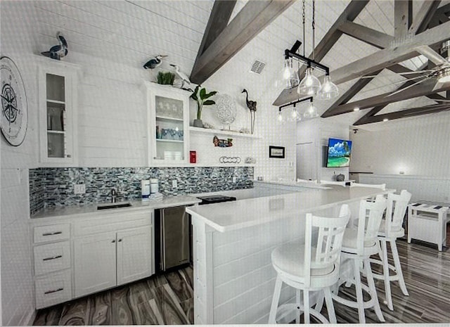 kitchen with tasteful backsplash, vaulted ceiling with beams, dark hardwood / wood-style floors, and white cabinets