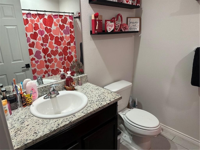 bathroom featuring tile patterned floors, vanity, and toilet