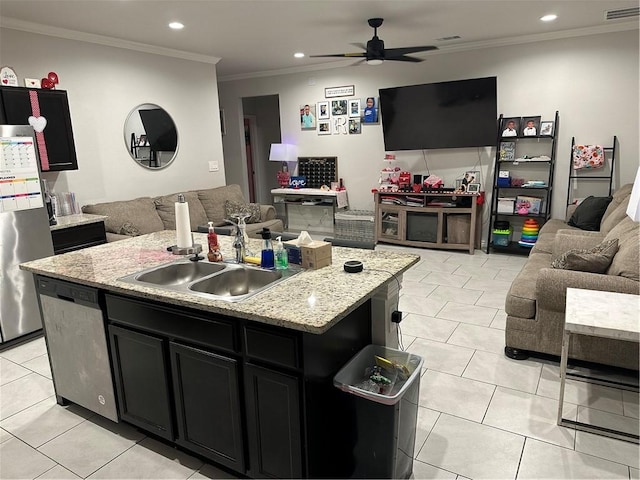 kitchen with appliances with stainless steel finishes, ornamental molding, sink, light tile patterned floors, and an island with sink