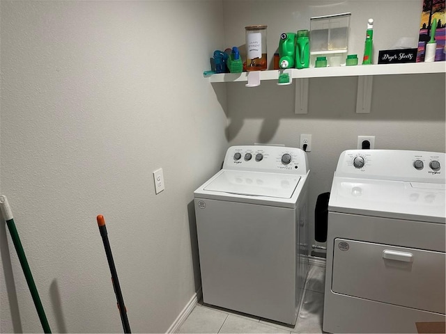 laundry area featuring light tile patterned flooring and washing machine and dryer