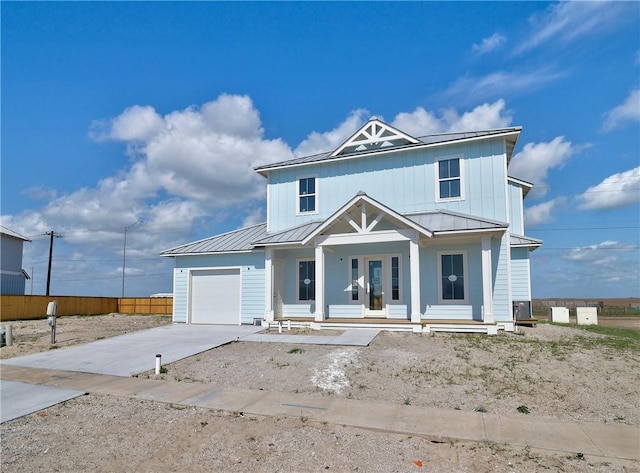 7518 Ruby Bay Ct, Port Aransas, TX 78373 - view of front facade with a porch, a standing seam roof, an attached garage, and concrete driveway