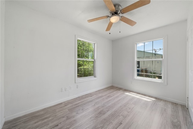 spare room with ceiling fan, plenty of natural light, and light wood-type flooring