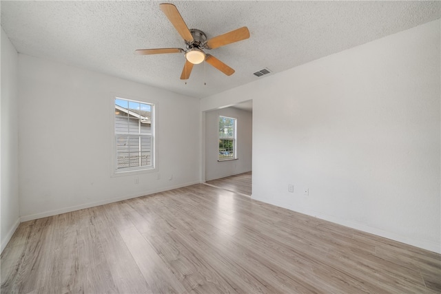 spare room featuring ceiling fan, a textured ceiling, and light wood-type flooring