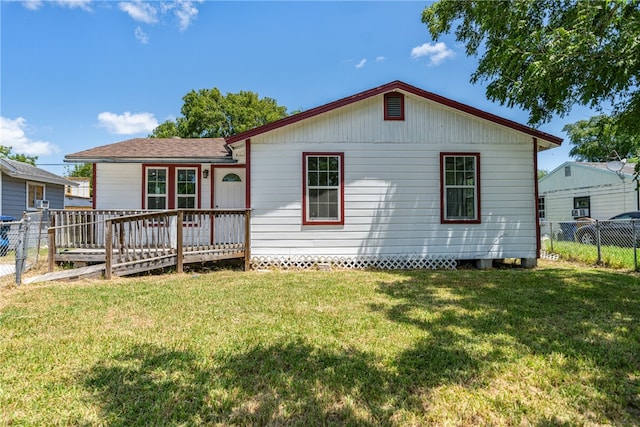 back of house featuring a yard and a wooden deck